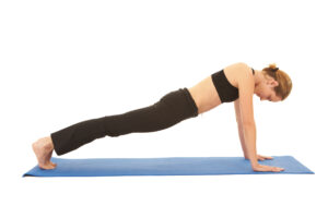 Fit young brunette pilates instructor showing different exercises on a white background a blue yoga mat. White background NOT ISOLATED