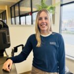 Smiling woman in gym in blue sweater