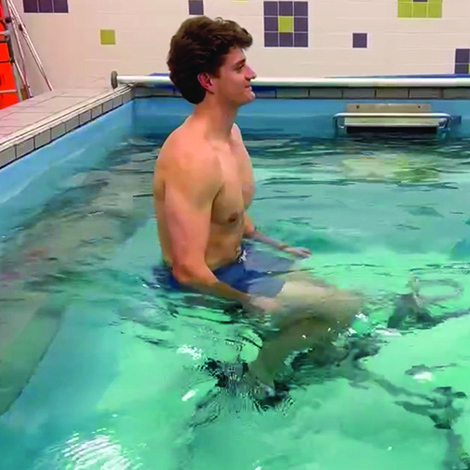 young man on exercise bike in pool