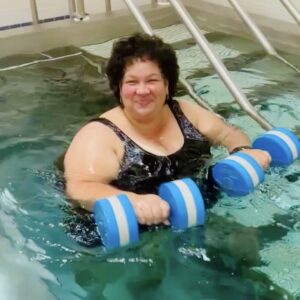 Woman exercising in water with dumbbells
